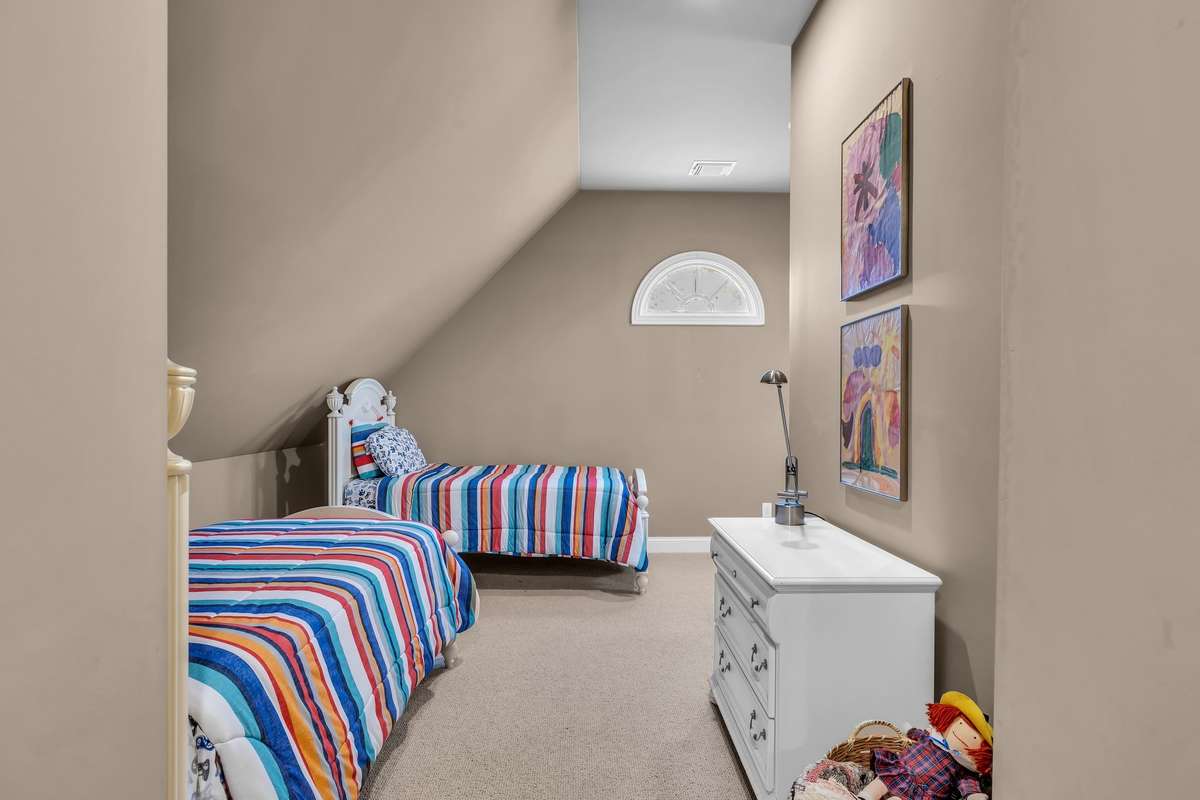Charming bedroom with vaulted ceiling and alcove—ideal for guests or playroom use.