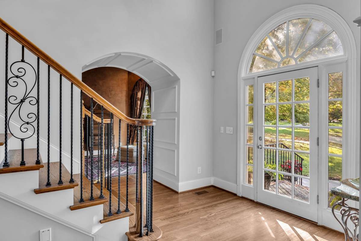 Light-filled entry showcases intricate millwork and inviting views of the landscaped front lawn.