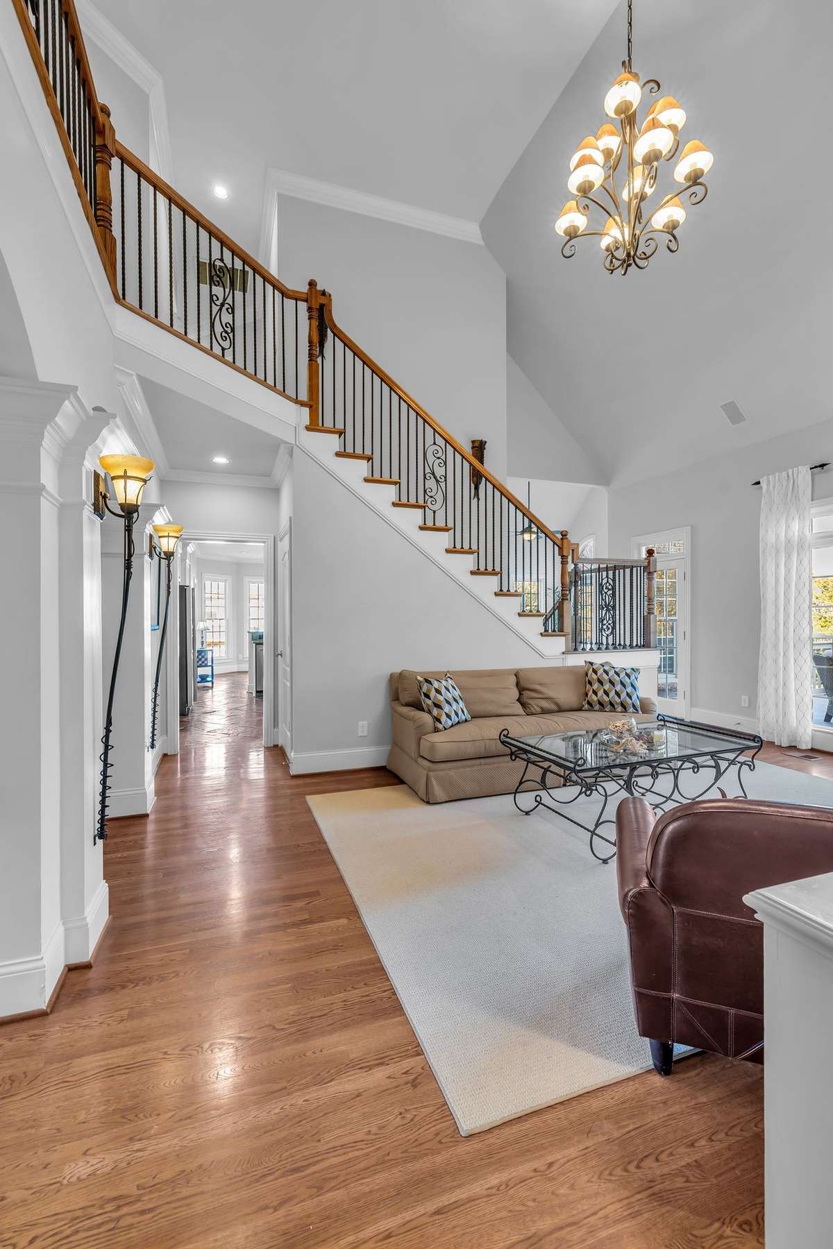 Soaring ceilings and custom ironwork staircase add grandeur to this inviting main living space.