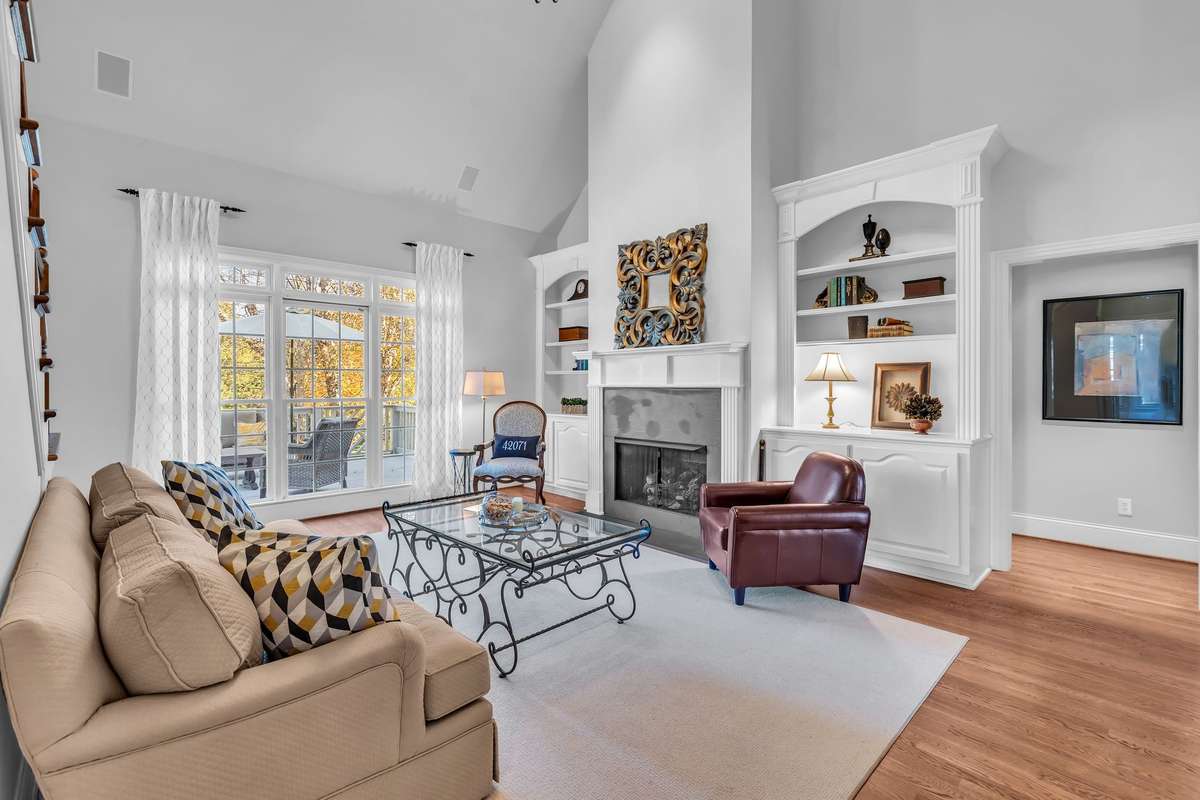 Bright and airy living room with a fireplace flanked by built-in shelving and abundant natural light.
