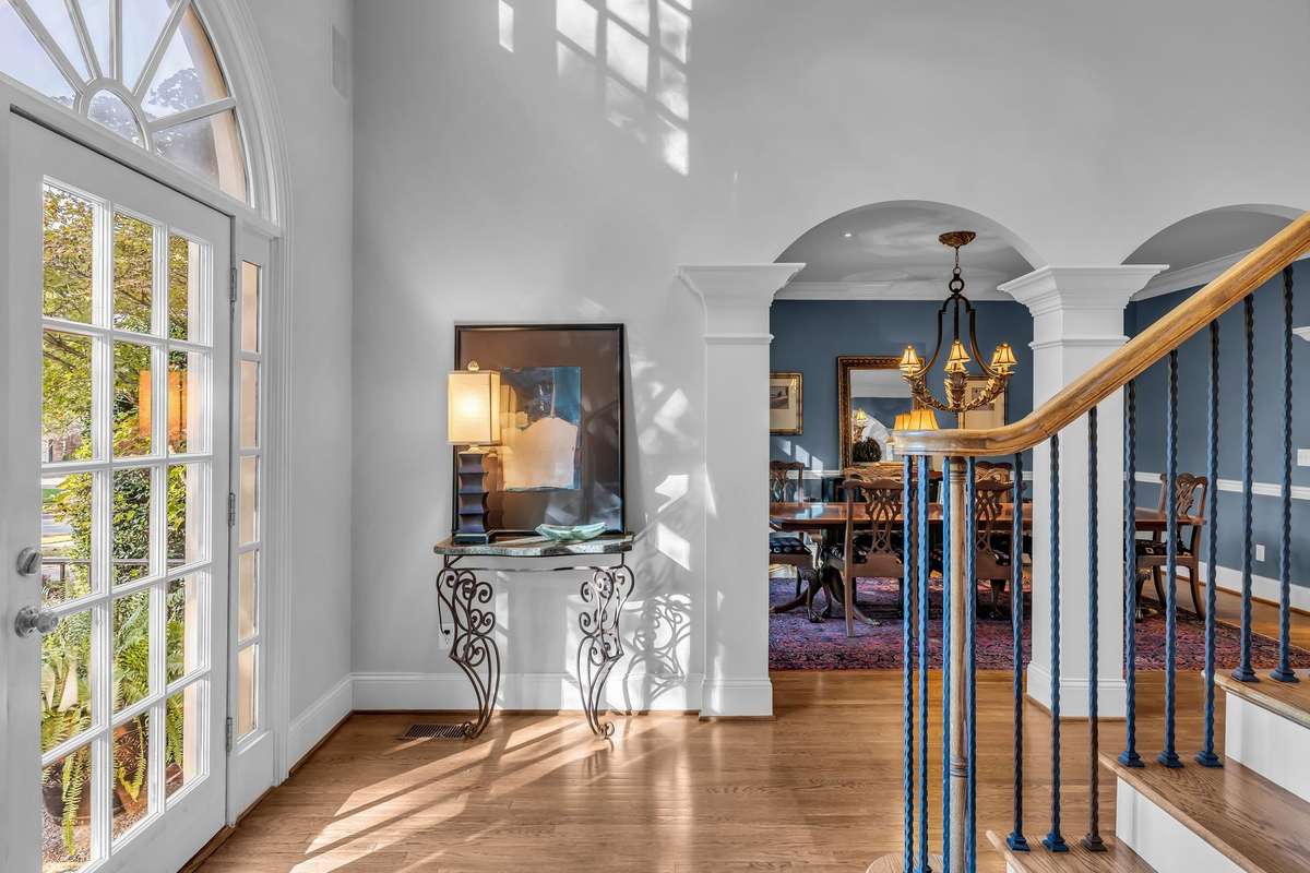 Graceful arches frame the view toward the formal dining room, blending classic architecture with warmth.