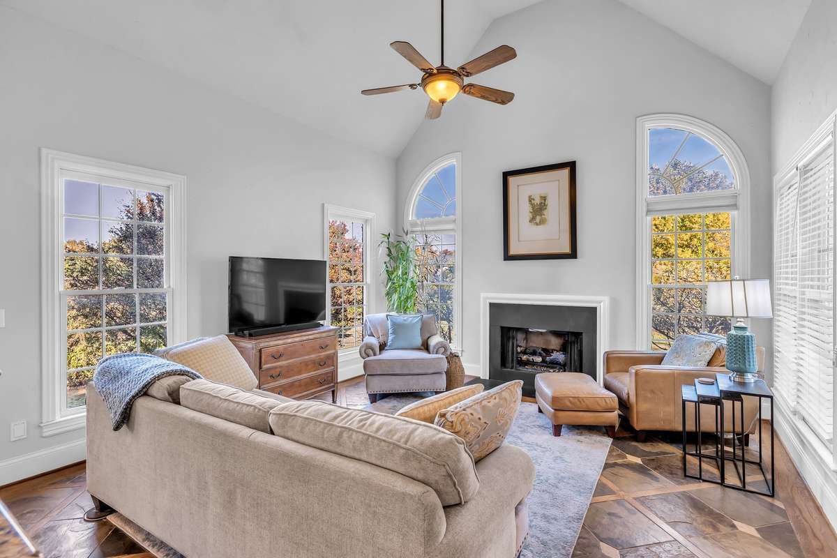 Vaulted ceilings and arched windows surround the second fireplace, filling the room with light and warmth.