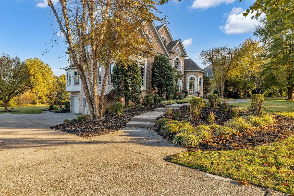 Beautifully manicured lawn and mature trees complement the elegant façade.