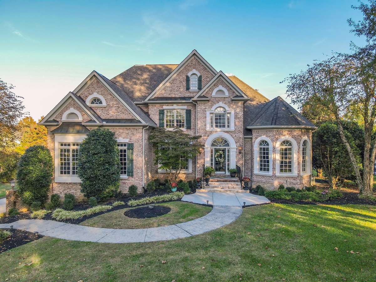 Stately all-brick exterior framed by lush landscaping creates an unforgettable first impression.
