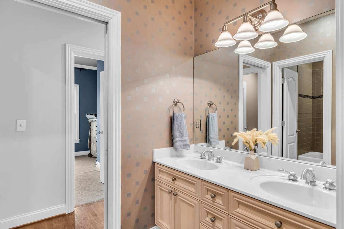 Jack-and-Jill bath with dual vanities, polished hardware, and timeless tile detailing.