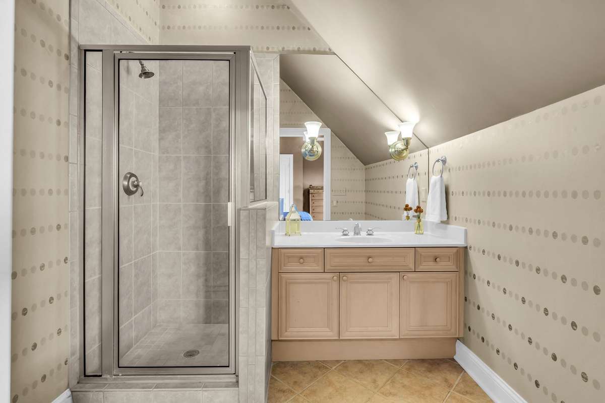 Private ensuite with walk-in shower, custom vanity, and designer lighting.