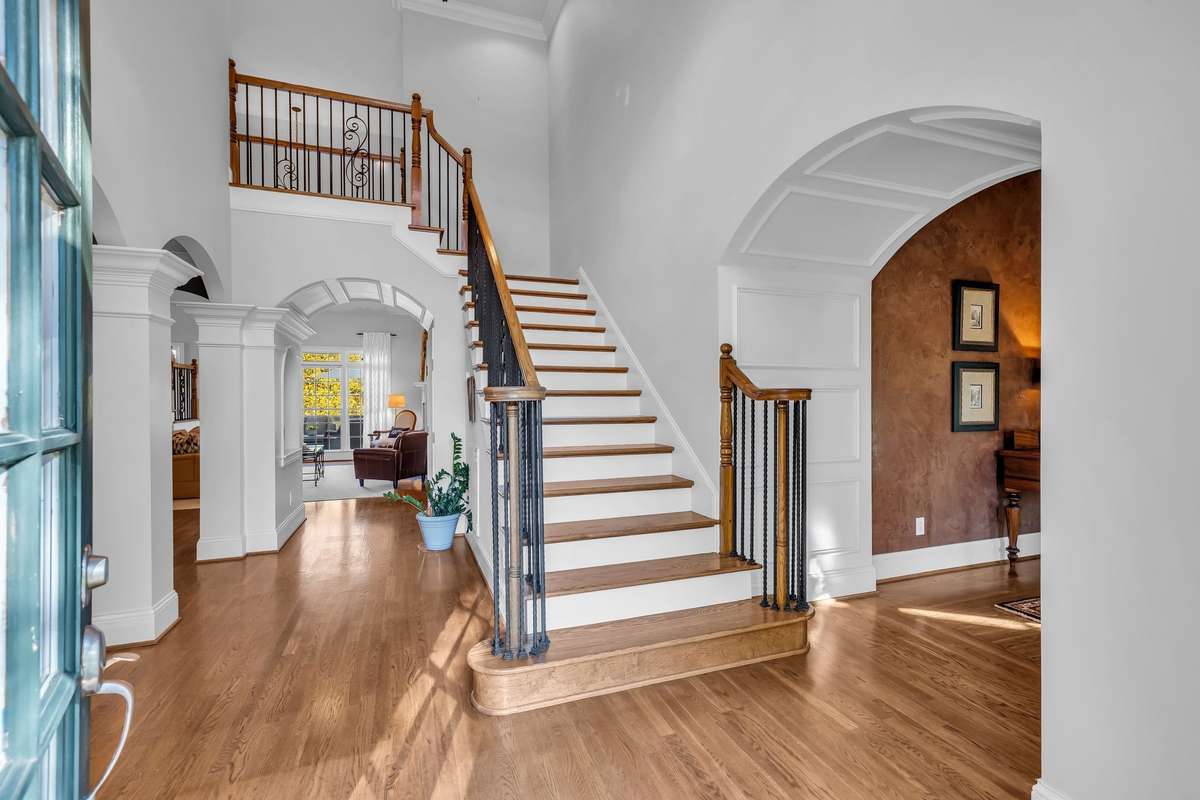 Elegant double staircase with wrought-iron detailing sets a tone of timeless sophistication.
