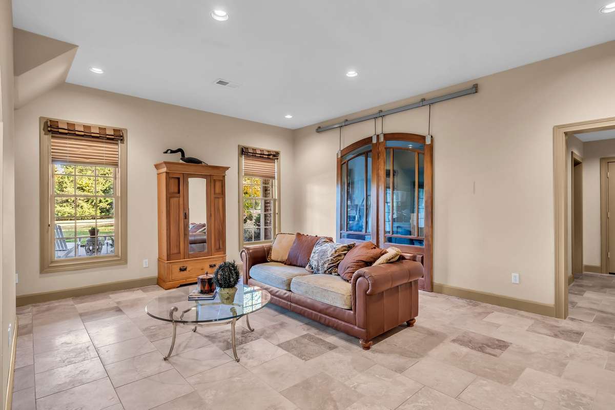 Full finished basement with tile flooring, recessed lighting, and patio access for effortless entertaining or in-law suite.