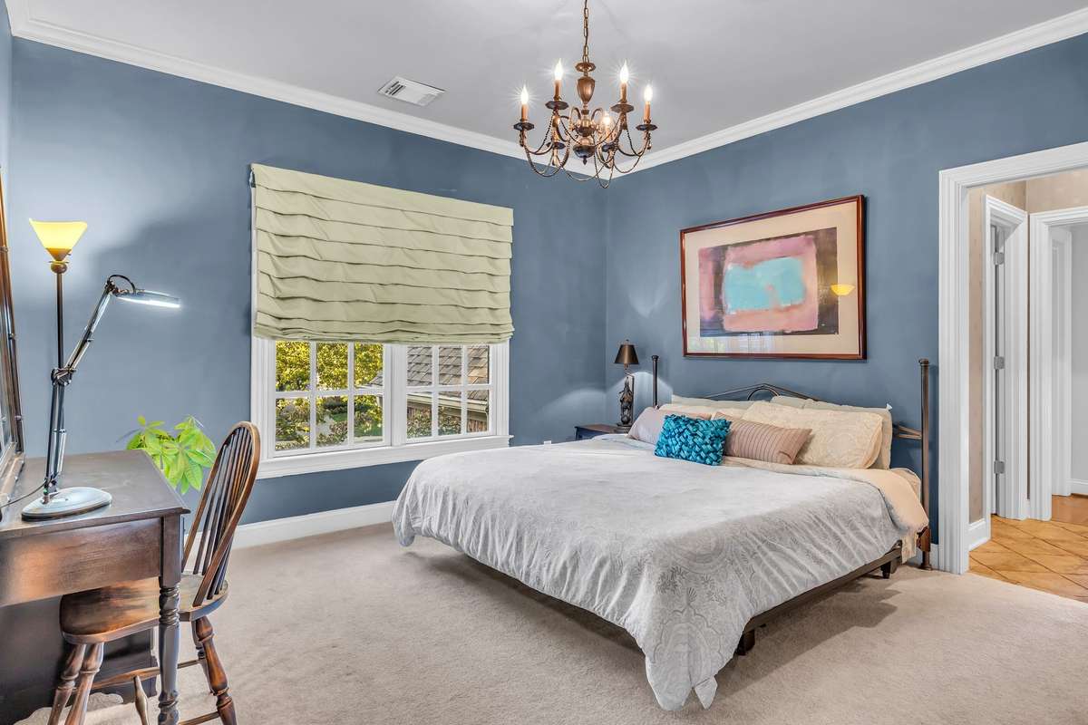 Charming guest bedroom with crown molding, stylish wall color, and ensuite access.