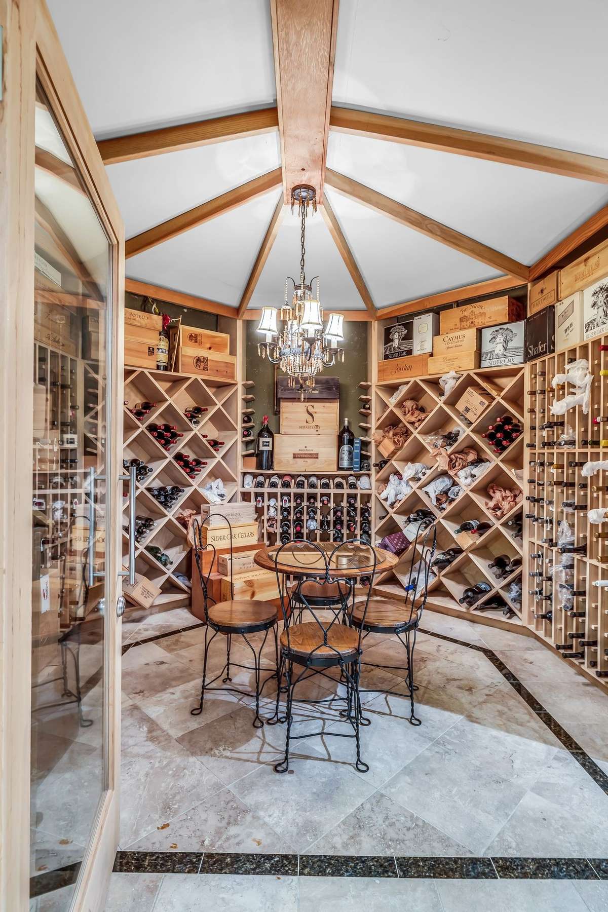 Architectural ceiling beams and chandelier lighting create a refined atmosphere for tastings and gatherings.