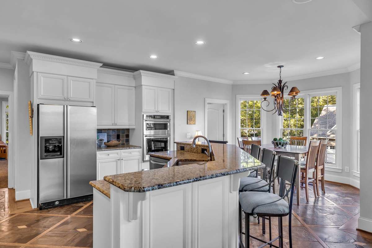 Gourmet kitchen with granite counters, custom cabinetry, and a large island for prep and seating.