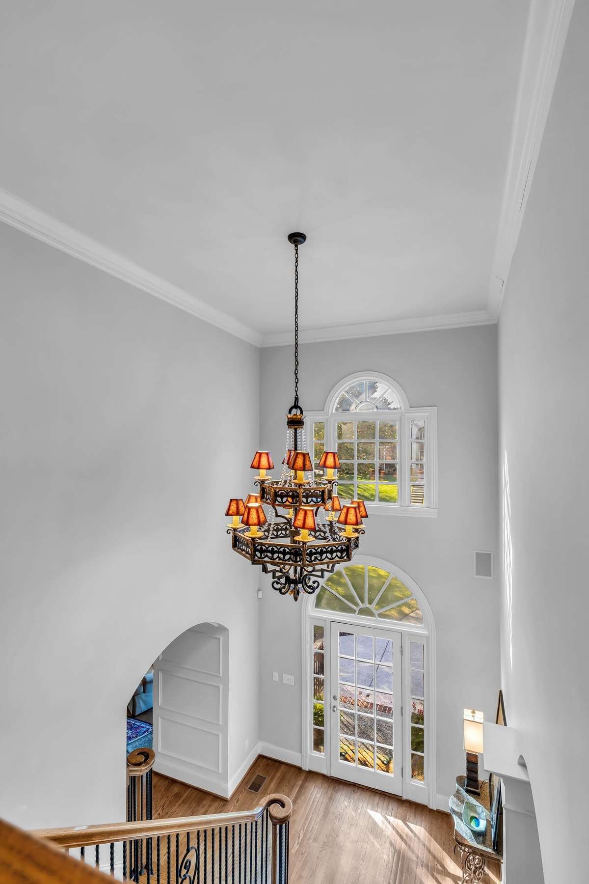 Statement chandelier and arched transom windows fill the entry with natural light and grandeur.