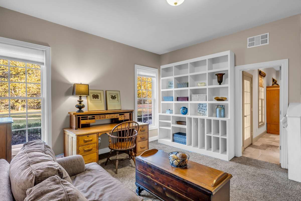 Bright lower-level room with built-in shelving—ideal for an office, hobby area, or study in basement area