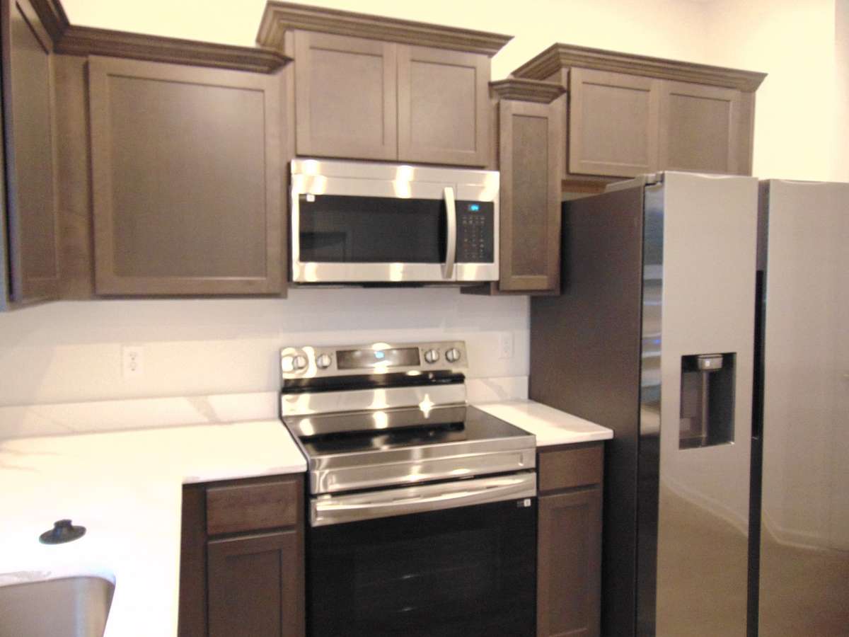 This is a sleek and modern kitchen to cook your family meals has stainless steel appliances and staggered cabinetry, as well as dreamy crowns
