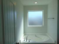 The primary bathroom has a soak in tub and shower, as well as two sinks.