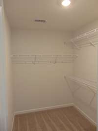 The primary closet with raised shelves for all your needs