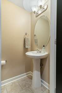 Guest half bathroom on the main level with fresh paint and ceramic tile floor