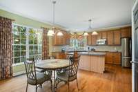 Kitchen with dining area, wood floors, island, crown molding and more