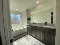 Primary bath offers a great soaking tub, double vanities, and large tile shower