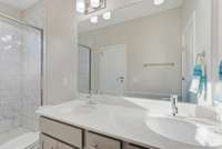 Primary bathroom with tiled shower and double vanities, en suite.