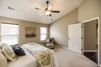 This spacious bedroom features large windows that bring in natural light, creating a bright and inviting atmosphere.