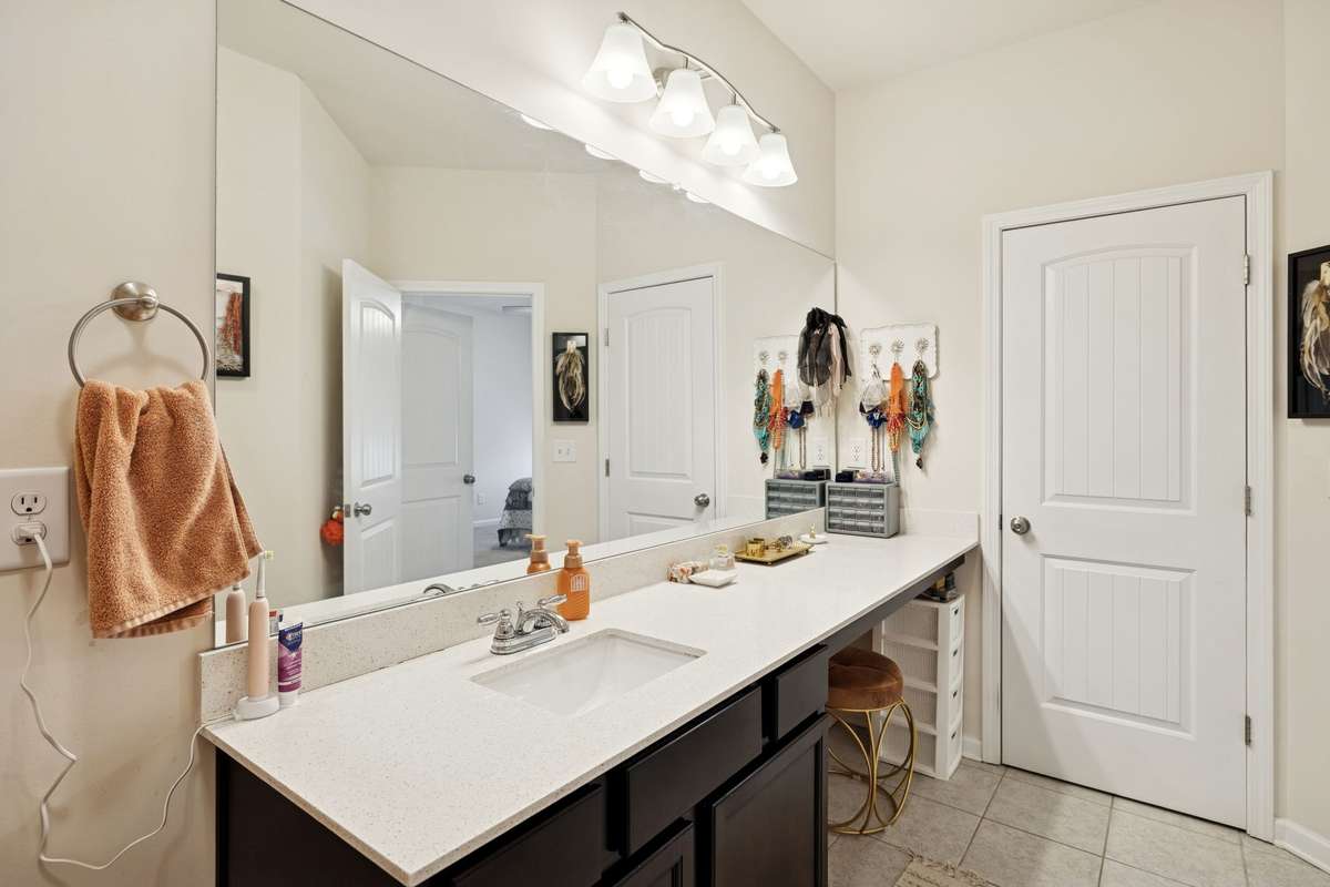 Primary bathroom has extended single vanity sink with sitting area.  2605 Sherman Way Columbia TN 38401