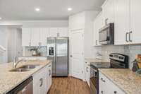 Notice the beautiful granite countertops and tiled backsplash.