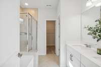 Primary Bathroom features a double vanity, step-in tiled shower, garden tub, private water closet, and walk-in closet.