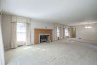 Massive living room with fireplace and open access to formal dining room. So many windows and natural light.
