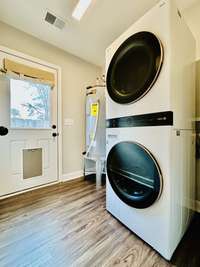 Laundry room with exterior door that has a doggie door installed. Leads to the large fenced in back yard.