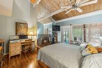 PRIMARY BEDROOM SUITE with wood burning fireplace, walk-in closet, double sink bath with door out to screened porch.
