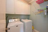 laundry room with extra shelving and cabinets