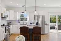 This is such a cheerful kitchen with all the natural light pouring in from the sliding glass doors and the window over the kitchen sink.  You'll have plenty of cabinet space surrounding all of the stainless steel appliances that remain with the home.