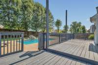 Large deck with room for plenty of furniture overlooking backyard and pool.  These posts have recently been cut down and railing repaired