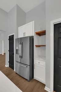 Stainless steel appliances add a sleek upscale touch, while large windows and glass doors fill the space with natural light and offer a beautiful view of the swimming pool just beyond.