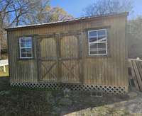Nice storage building with shelves to stay on property.