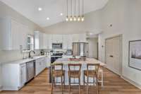 The kitchen features an oversized island with storage and ample room for seating, quartz countertops, stainless appliances, white shaker cabinetry with soft-close drawers.  Refrigerator, Range, Dishwasher, and Microwave-- all stay with the property!