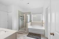 Primary bathroom with tiled walk-in shower, soaking tub, and double vanity.