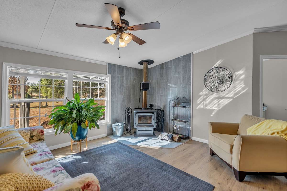 Upon entering, you are greeted by a bright open-concept floor plan that flows effortlessly from room to room, ideal for entertaining and family gatherings. Imagine curling up by the charming, wood-burning fireplace on a chilly evening