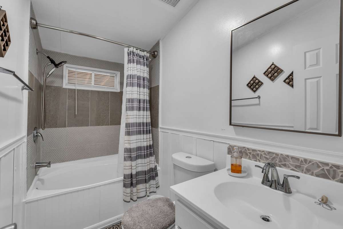 The second bathroom is a lovely space, complete with a nice soaking tube shower combination