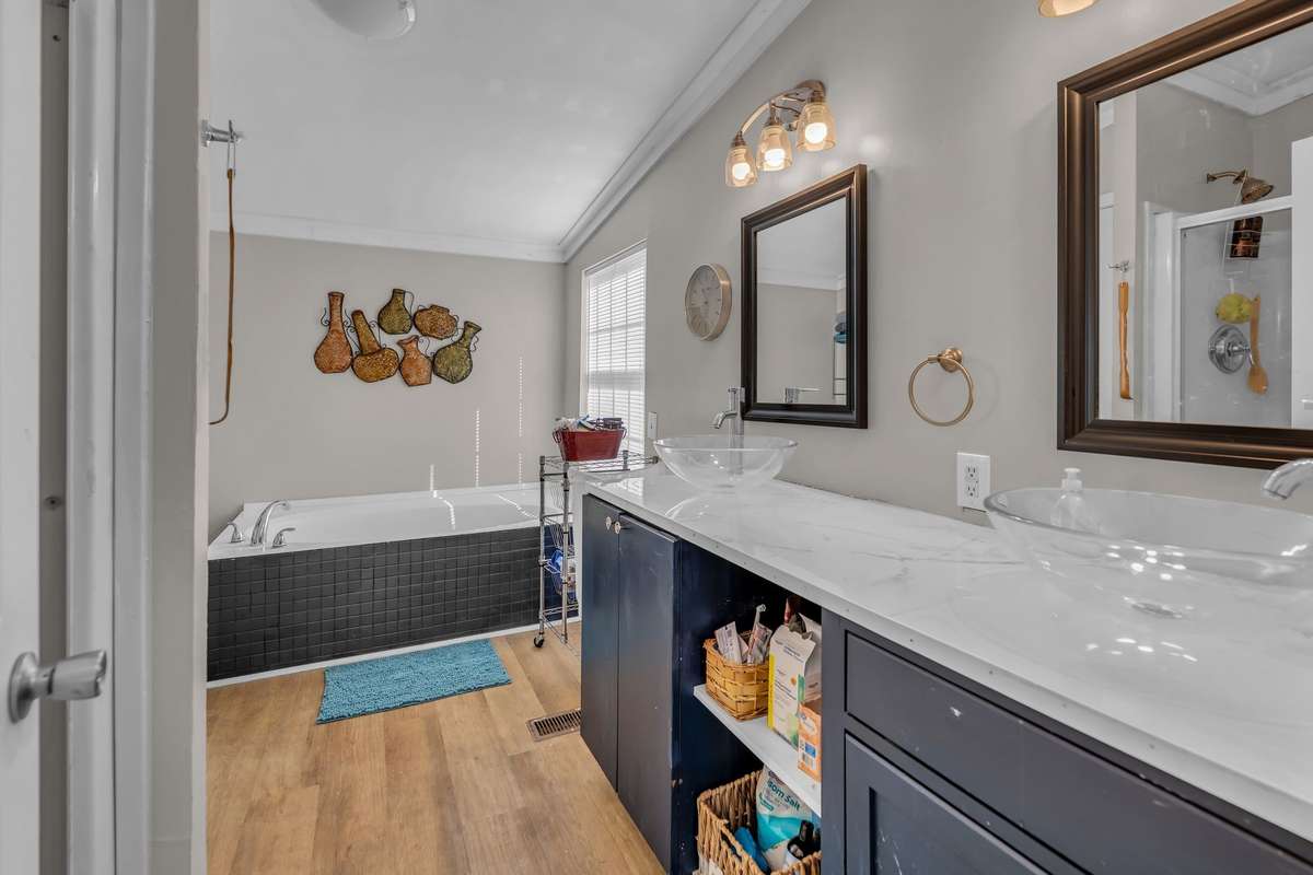 The ensuite bathroom features upgraded vessel sinks