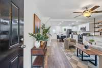 The front door opens to fresh paint, wood floors, and an open floor plan.