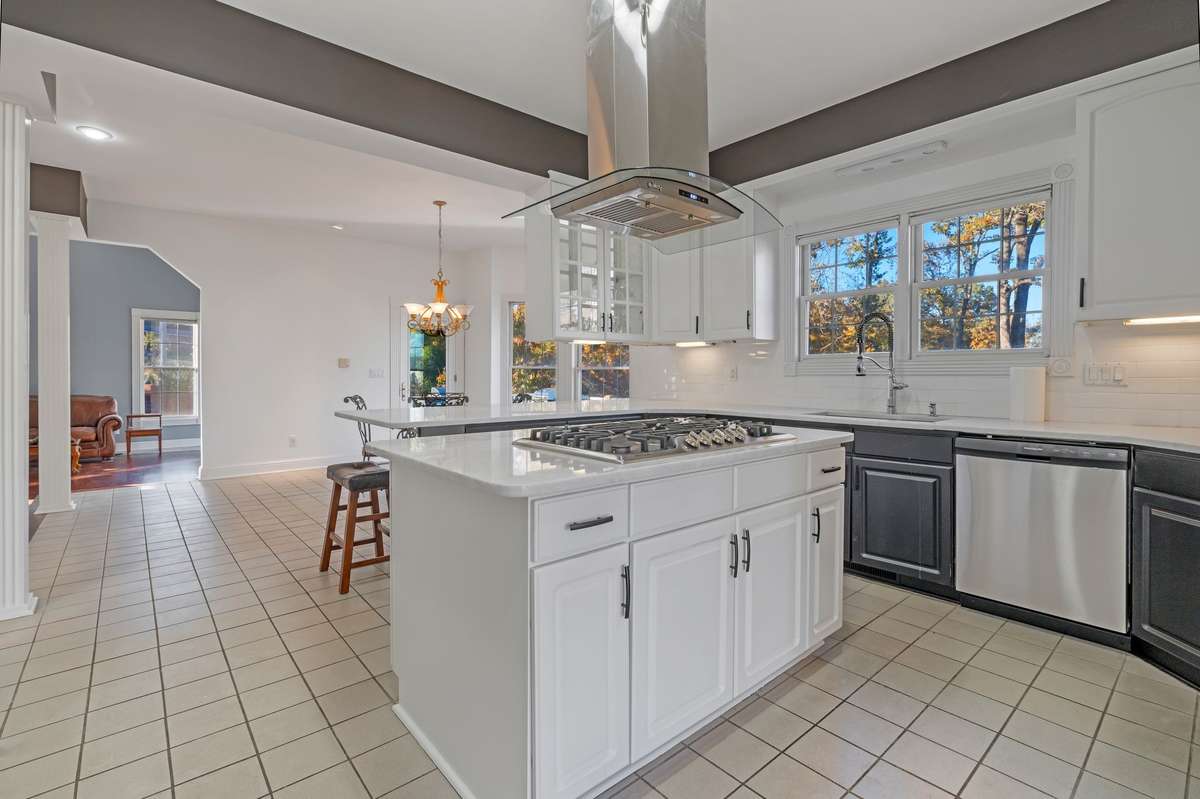 A renovated kitchen is so functional and has new appliances, a new sink, a new faucet, new hardware and fresh paint. The cabinet color and trim color make the kitchen pop. There is plenty of additional storage just to the left in this photo.