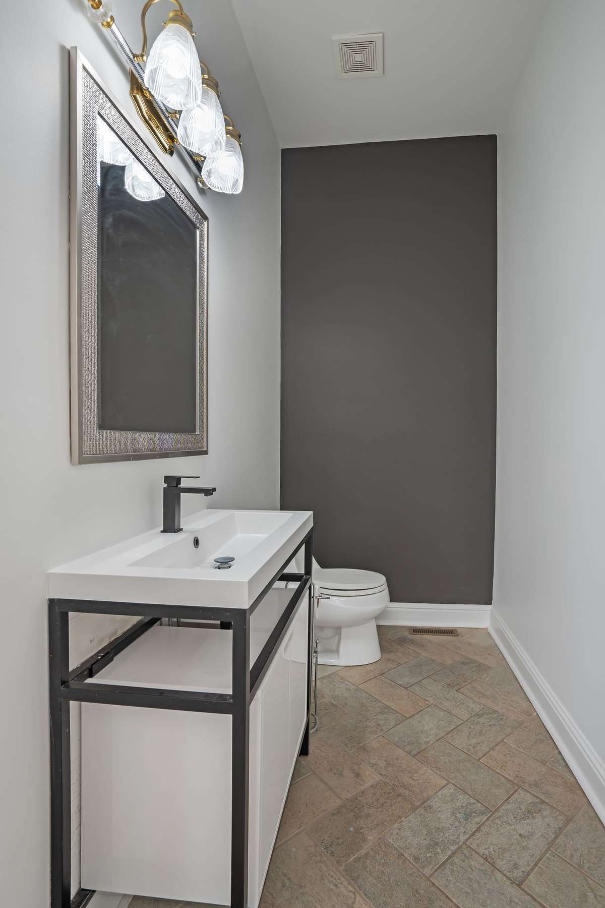 Completing the main level living spaces is this fully renovated half bathroom, including a quartz counter top.