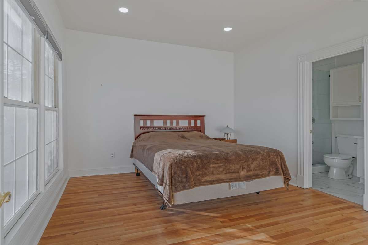 The third bedroom upstairs also has new laminate flooring, large windows, recessed lights, and an ensuite bathroom.