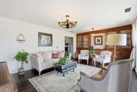 The bright formal living room has custom built ins and a large window for lots of natural light