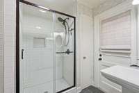 Second full bathroom with classic white subway tiled shower and pedestal sink