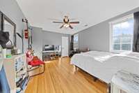 Comfortable bedroom with two windows, hardwood flooring, and plenty of space.