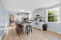 Additional view of the kitchen showcasing the center island with bar seating, abundant cabinetry, and easy access to the dining room.
