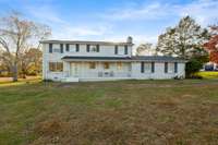 Front Exterior
Two-story brick exterior with classic shutters and a covered front porch. The wide front yard offers an open view of the property and surrounding landscape.